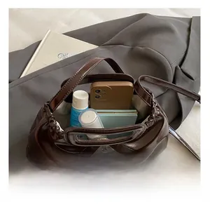 Interior view of brown pleated shoulder bag showing storage for phone and cosmetics