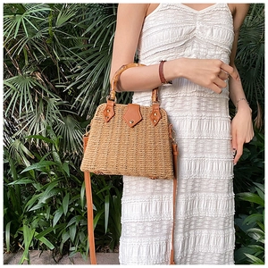 Detailed texture of straw weave featuring bamboo handle and leather strap for beach bag