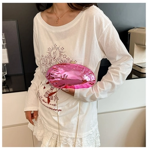 Dettaglio di una pochette metallica rosa acceso con catena dorata per abiti da sera