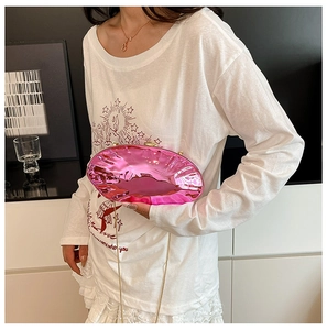 Clutch rosa metallizzato a forma di conchiglia con catena dorata indossata da modella