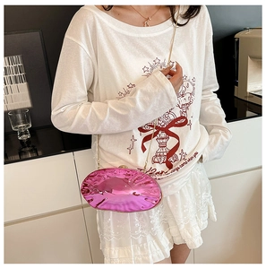 Dettaglio pochette ovale rosa specchiato lucido con catena dorata e trama metallica brillante
