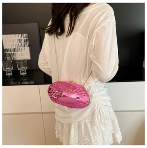 Dettaglio della borsa da sera rosa metallizzato con catena dorata indossata da una modella