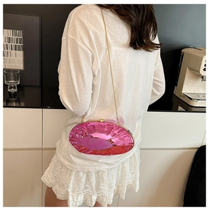 Dettaglio borsa a mano plissettata rosa metallizzato con catena dorata sottile