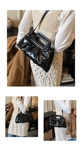 Detail of glossy black patent leather bag featuring unique pleated texture and rectangular handle