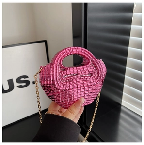 Macro detail of hot pink woven texture mini bag with elegant gold chain and top handle