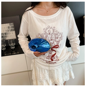 Dettaglio della pochette da sera in acrilico blu reale con catena dorata su modella