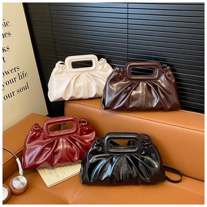 Detail view of four pleated glossy leather handbags in beige, tan, burgundy, and black