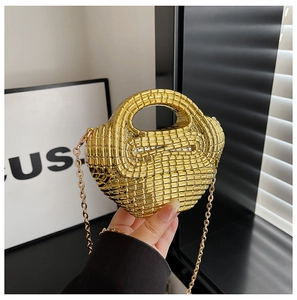 Detail of gold acrylic woven handbag showing metallic texture and handle craftsmanship