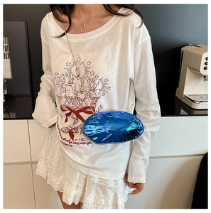 Dettaglio pochette in acrilico blu reale con trama marmorizzata e catena d'oro