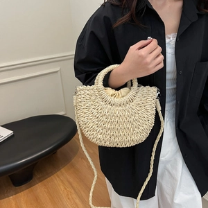 Woven half-moon beach bag in cream white with drawstring closure and crossbody strap