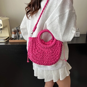 Pink woven crossbody bag with round handle and drawstring liner for summer beach vacation