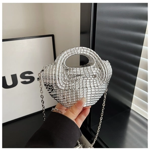 Detail of silver woven acrylic clutch with metallic chain strap for shoulder wear