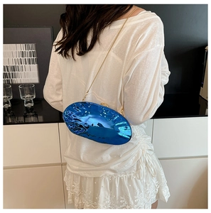 Dettaglio della borsa blu metallizzata a forma di uovo con tracolla dorata