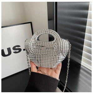 Detailed macro view of the silver acrylic woven texture on a mini metallic handbag