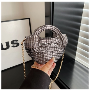 Detailed macro view of silver woven acrylic mini bag with gold chain strap accessory