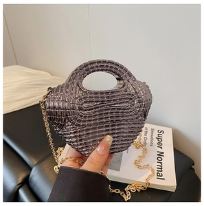 Detail of metallic gunmetal woven mini bag with luxury gold chain strap and top handle
