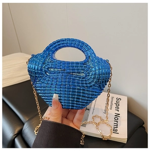 Detail of bright blue mini chain bag featuring a unique woven texture and gold metal strap