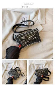 Detail of black punk waist bag with silver rivets and magnetic triangular flap