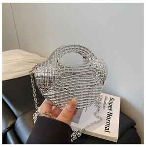 Detailed view of hand-held silver woven beaded handbag with reflective metallic finish