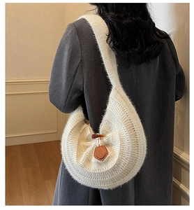 Detailed knit texture of a white slouchy hobo bag with leather horn buckle accent