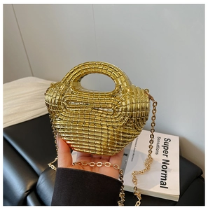 Close-up of golden acrylic woven handbag with beaded texture and metal chain strap