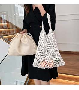 Detail of handmade crochet hollow mesh bag with a beige cotton drawstring inner pouch