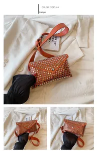 Detail view of orange punk style mini belt bag with silver metal rivets and envelope flap