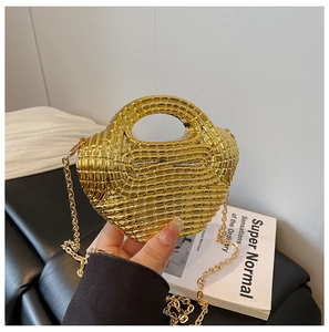 Detail of gold woven acrylic handbag with metallic texture and sleek chain strap