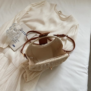 French style straw woven handbag with brown leather straps on white textured dress