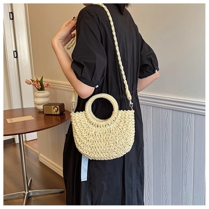 Détail du sac en paille tissé à la main avec poignées rondes et bandoulière de style bohème