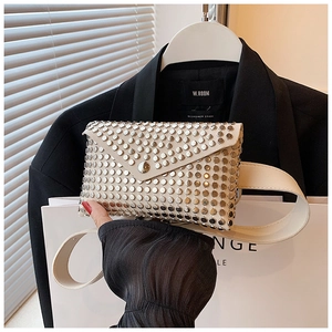 Detail of beige punk style waist bag featuring silver studs and envelope flap design
