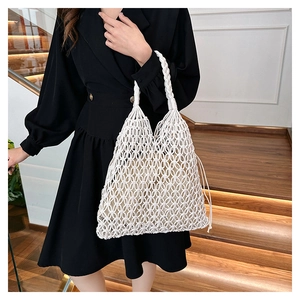 Detail of white cotton rope woven bag with hollow diamond grid and inner drawstring pouch