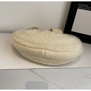 Détail d'un sac à main en maille crème montrant la texture mohair et les rayures