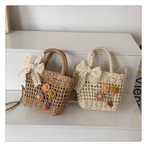 Dettagli di borse in paglia intrecciata a mano con fiocchi in pizzo e fiori colorati
