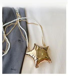 Détail du sac de soirée doré en forme d'étoile avec perles et bandoulière chaîne