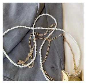 Détail de la bandoulière en perles et chaîne dorée avec breloque de sac en forme de chat
