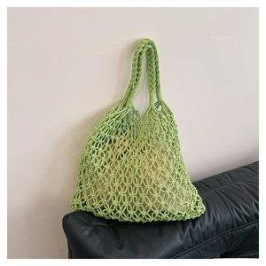 Detailed close-up of light green hand-woven cotton rope bag featuring a geometric mesh pattern