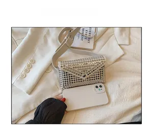 Size comparison showing a silver studded envelope waist bag next to a smartphone