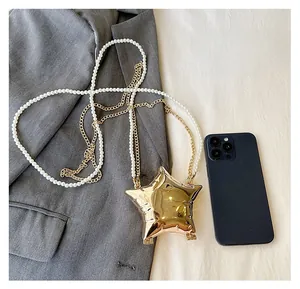 Comparaison détaillée montrant la taille du mini sac de soirée étoile à côté d'un smartphone