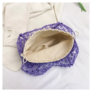 Detailed knit texture of purple crochet bag with beige drawstring lining on white fabric