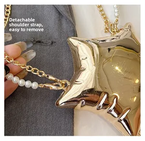 Détail de la bandoulière amovible en perles blanches et chaîne dorée du sac étoile
