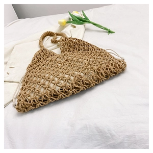 Close-up of khaki woven cotton rope handbag with hollow mesh texture and inner pouch