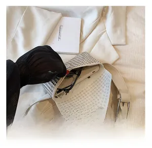 White rhinestone handbag interior showing storage capacity for phone and glasses