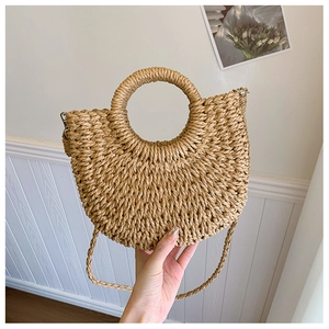 Vue détaillée du sac en paille tressée avec poignée ronde et design demi-lune estival