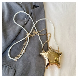 Vue détaillée d'un sac de soirée en forme d'étoile dorée avec chaîne en perles et métal
