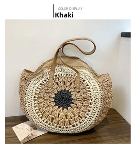 Detail of round straw beach bag with khaki contrast weaving and durable leather handles