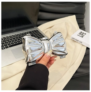 Detailed view of silver bow-shaped acrylic clutch with wrinkled texture and metal chain