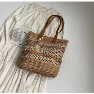 Détail du sac cabas en paille tressée à carreaux avec franges et perles en bois