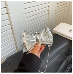 Close-up of a metallic silver bow-shaped clutch bag with sleek chain strap detail
