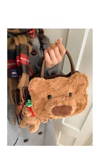 Detail of plush bear handbag with brown leather handle and mini 3D teddy decoration